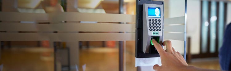 Someone scanning their finger on a security pad to enter an office