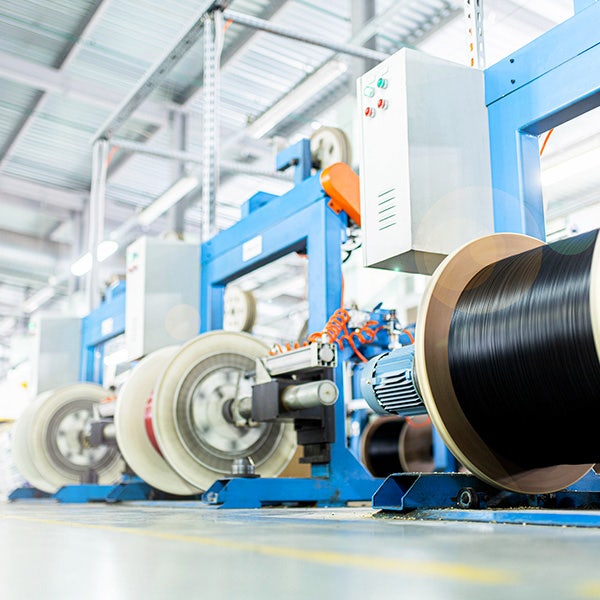 Wire reel holders being assembled by a bright blue robotics machine