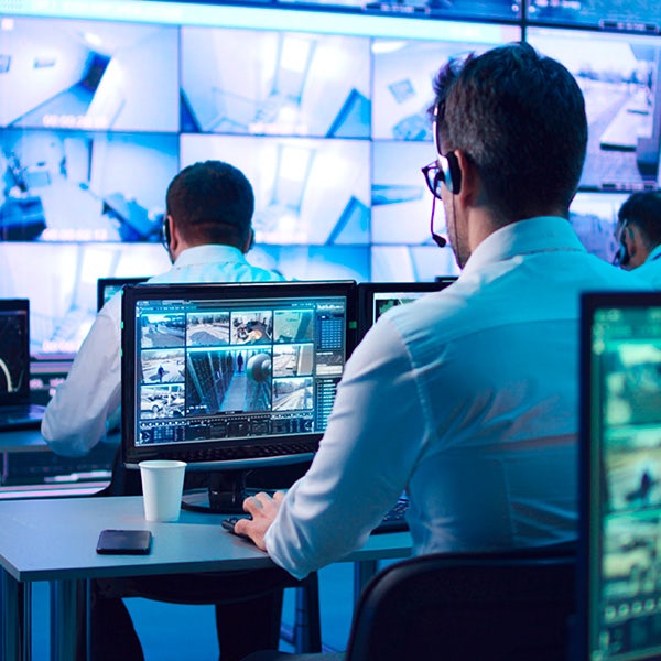 A man associate looking at a desktop with security footage on it