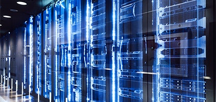 Rows of servers that have a blue glow in a data center