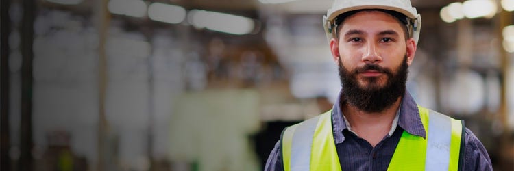A man with a beard in a bright vest smiling at you