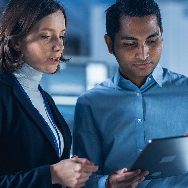 Two technical specialists have a conversation while holding a tablet