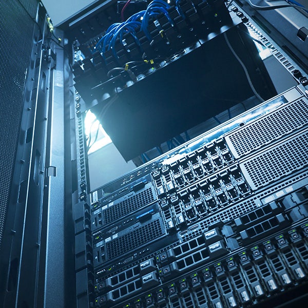 Inside of a server in a data center filled with blue cables and switches